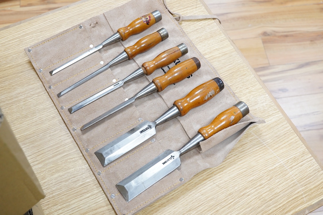 Five woodworking chisel sets, all in leather rolls, including an unused nine piece set by Robert Sorby, a six piece set by Henry Taylor, and three other sets showing some wear